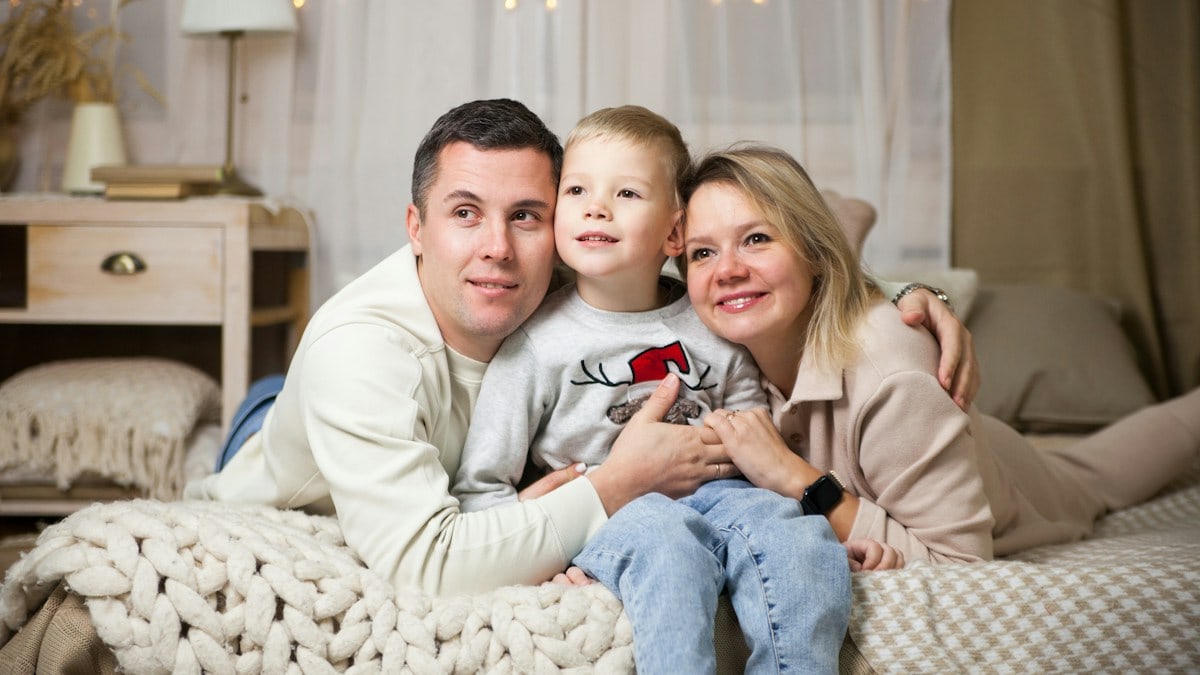a man and woman with a child on a couch